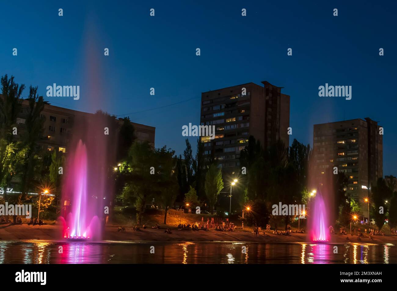 The musician and lighting fountains at the night city Stock Photo - Alamy