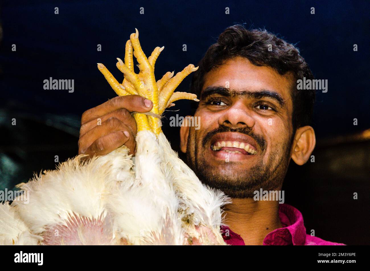 Vendor presenting chicken for sale at the chicken market Stock Photo