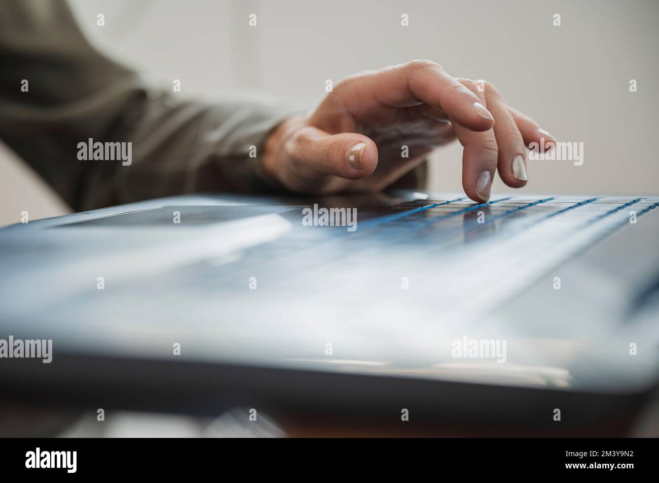 Low angle closeup view of female hand typing and using black laptop computer keyboard. Stock Photo