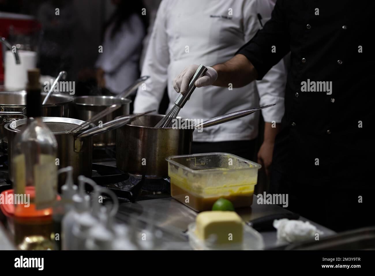 A cook stirring pots in the kitchen. Big pots in the kitchen. gastronomy education Stock Photo