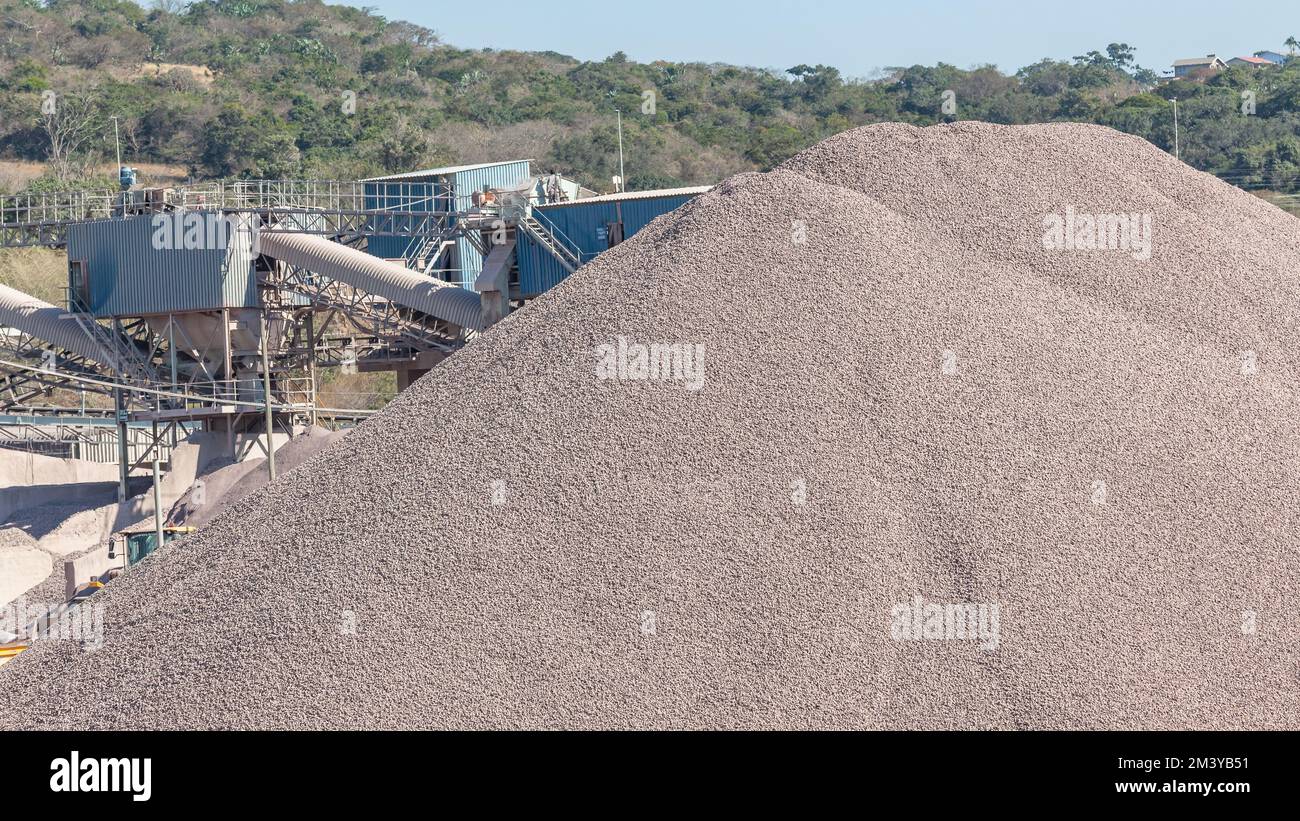 Stone Quary Industrial Factory in countryside with large pile mound of  graded stone processed for construction industry. Stock Photo