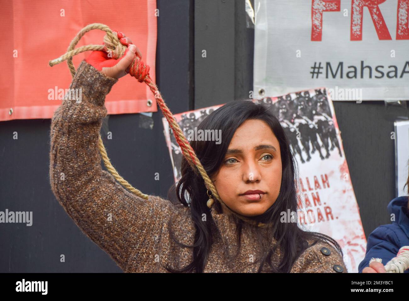 London, UK. 17th December 2022. A group of women staged a demonstration and performance in Piccadilly Circus in protest against the reported executions of anti-government protesters in Iran. The activists tied ropes around their necks and covered their hands in fake blood. Credit: Vuk Valcic/Alamy Live News Stock Photo