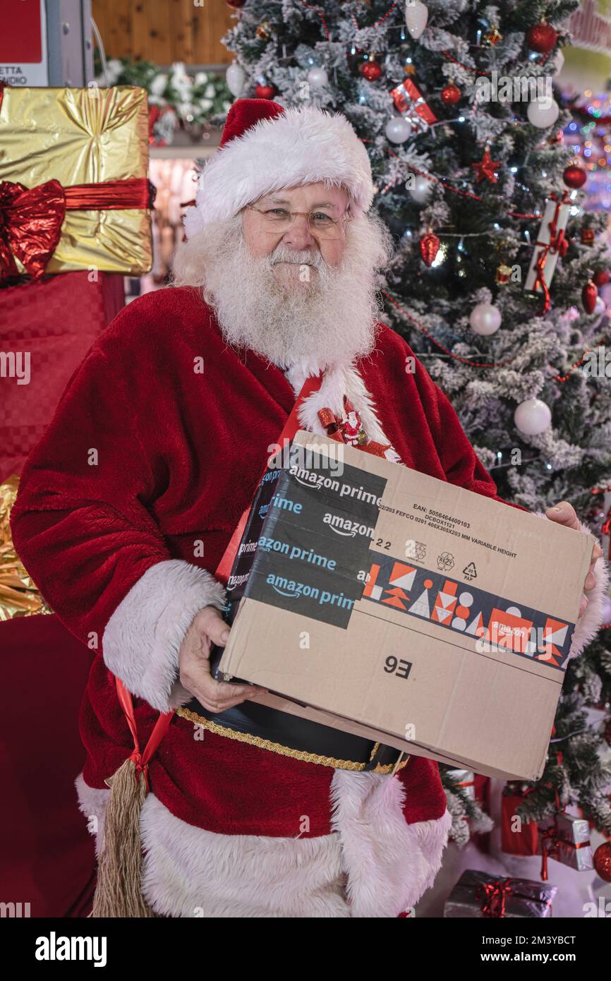 Santa Claus holding Christmas gifts ordered from Amazon. Milan Italy - December 2022 Stock Photo