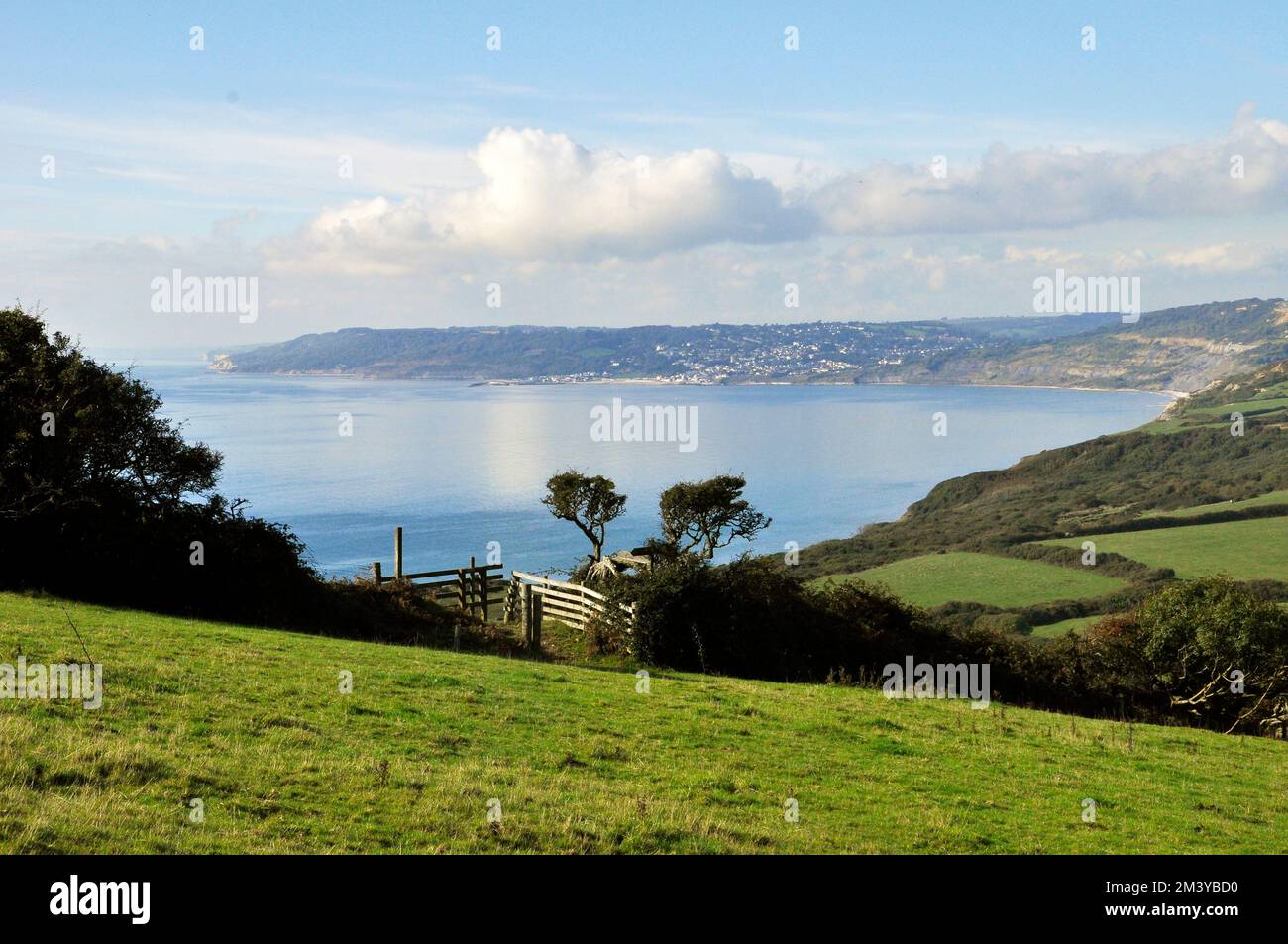 A distant autumn view of Lyme Regis on the coast of Dorset from the path around Golden Cap the highest point on the Dorset coast. Stock Photo
