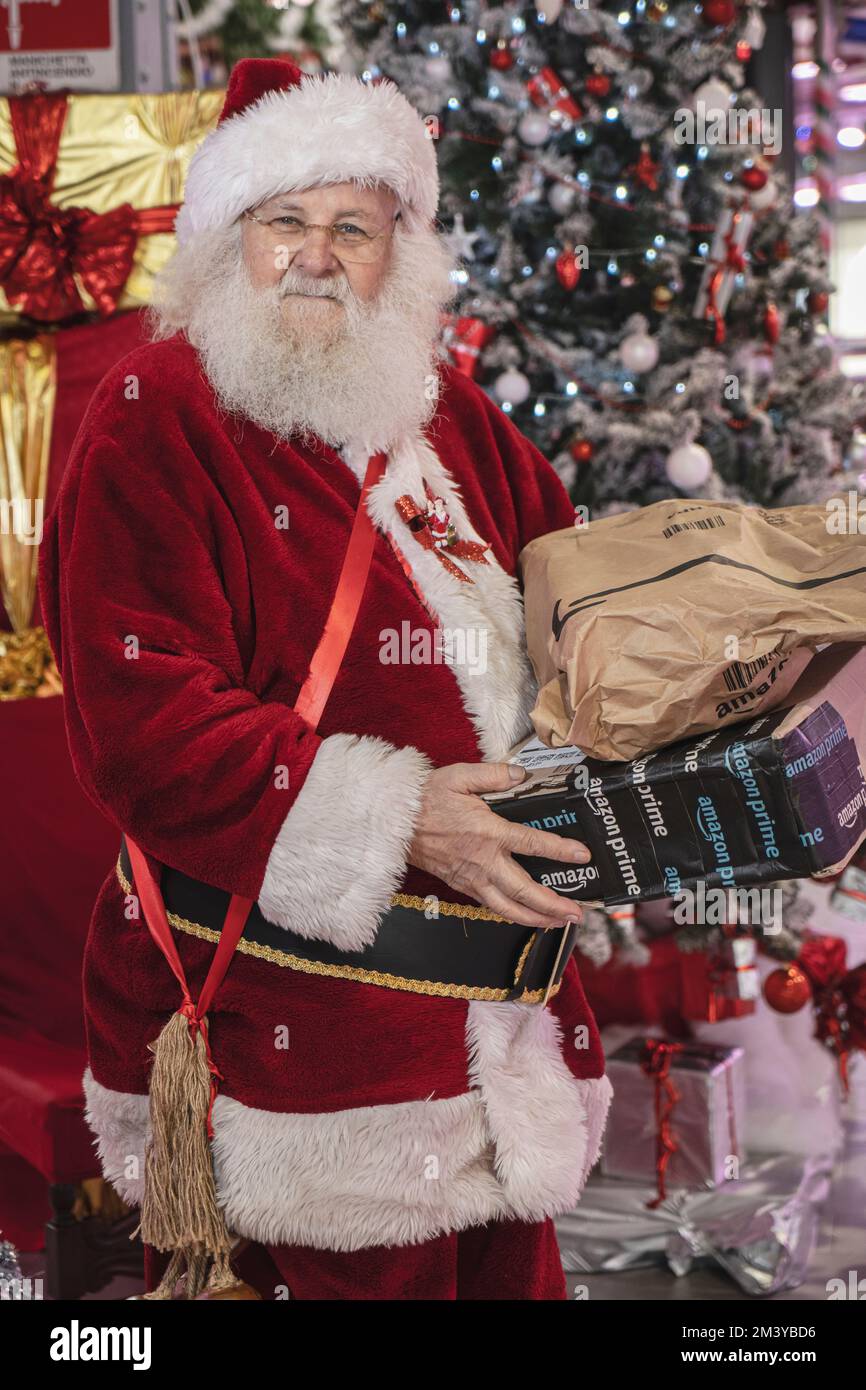 Santa Claus holding Christmas gifts ordered from Amazon. Milan Italy - December 2022 Stock Photo