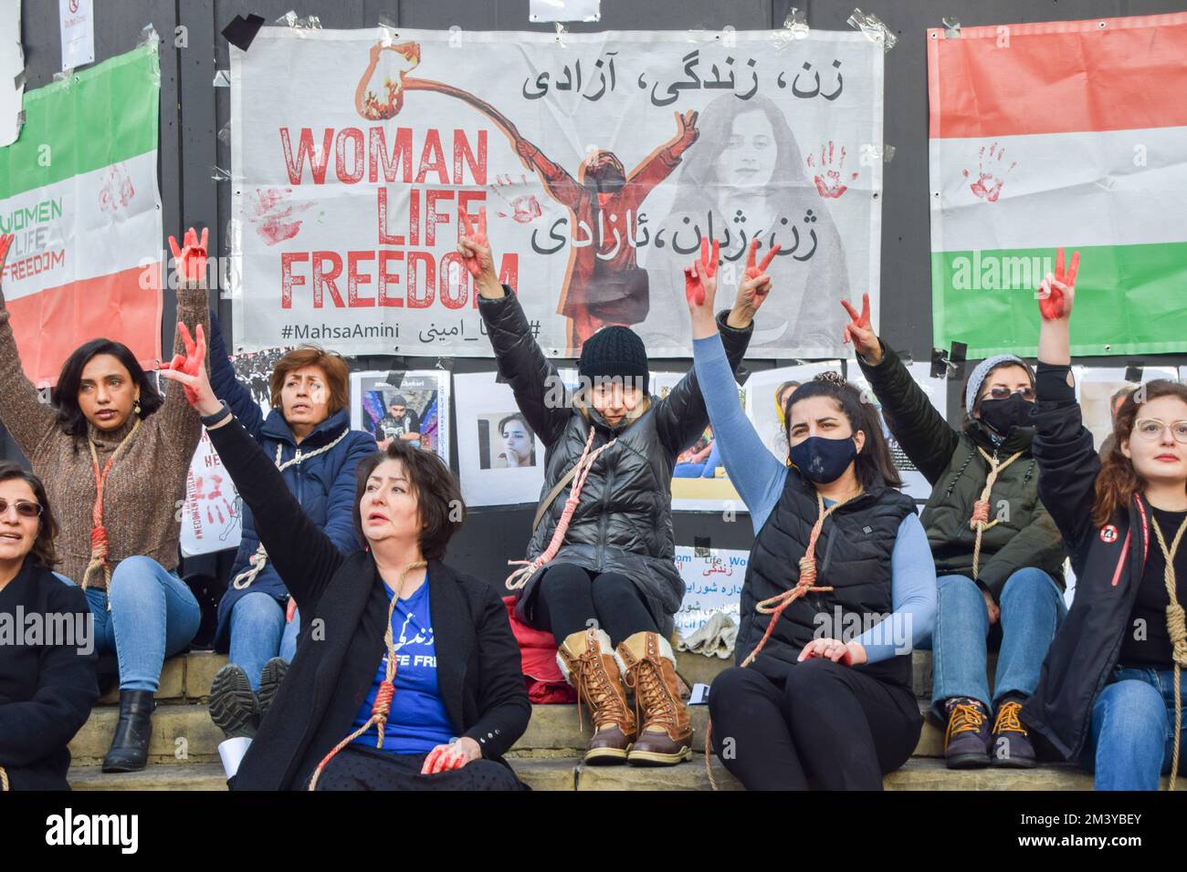 London, UK. 17th December 2022. A group of women staged a demonstration and performance in Piccadilly Circus in protest against the reported executions of anti-government protesters in Iran. The activists tied ropes around their necks and covered their hands in fake blood. Credit: Vuk Valcic/Alamy Live News Stock Photo