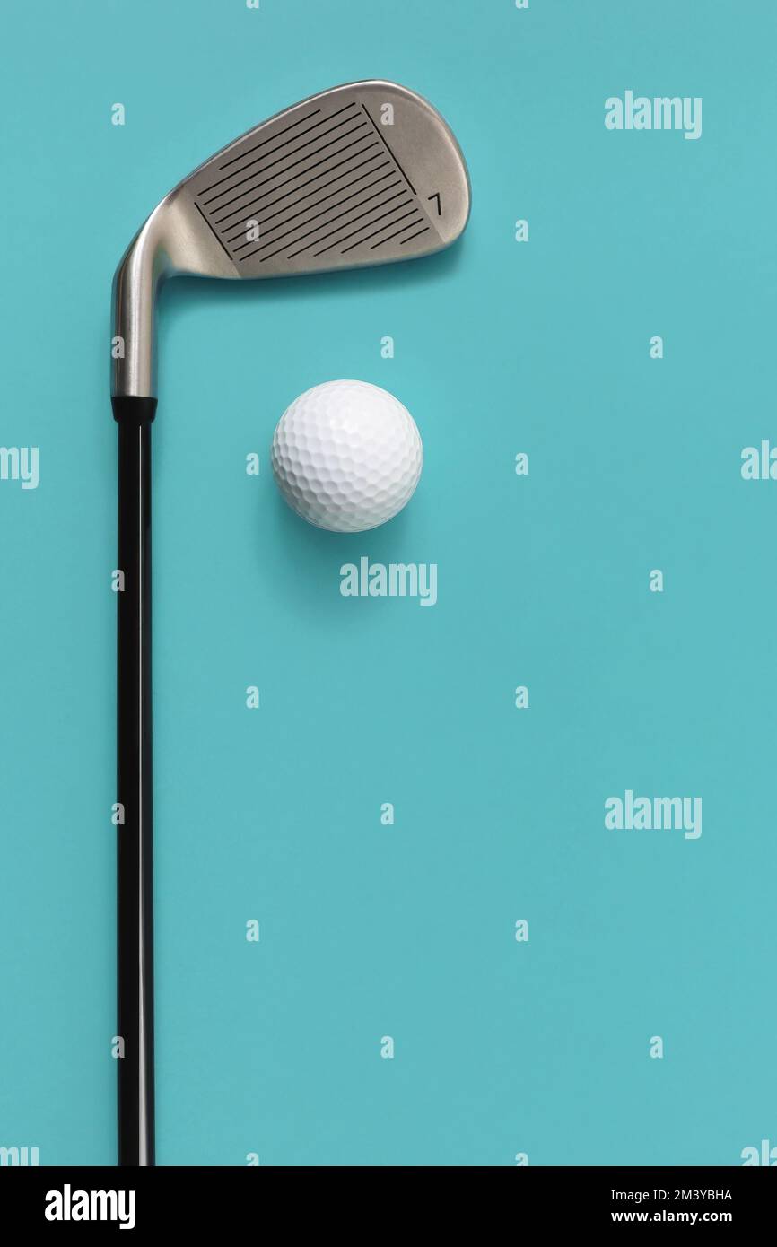 Golf club and golf ball isolated on light turquoise blue background