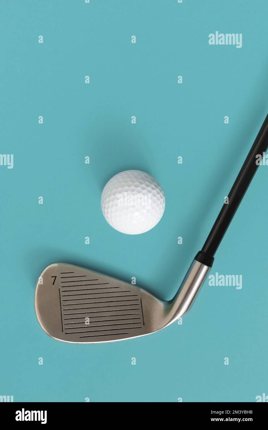 Closeup of golf club and golf ball isolated on light turquoise blue background. Space for text. Stock Photo