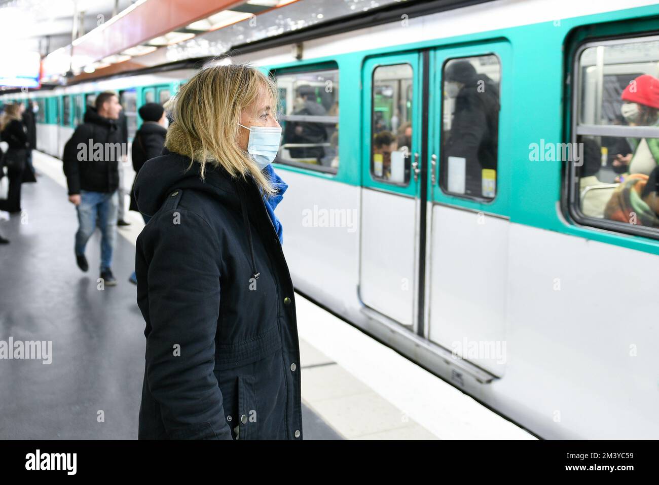 A person (woman passenger) wearing a surgical blue mask on public transport due to the Covid-19 (coronavirus) pandemic, on December 16, 2022 in Paris. Stock Photo