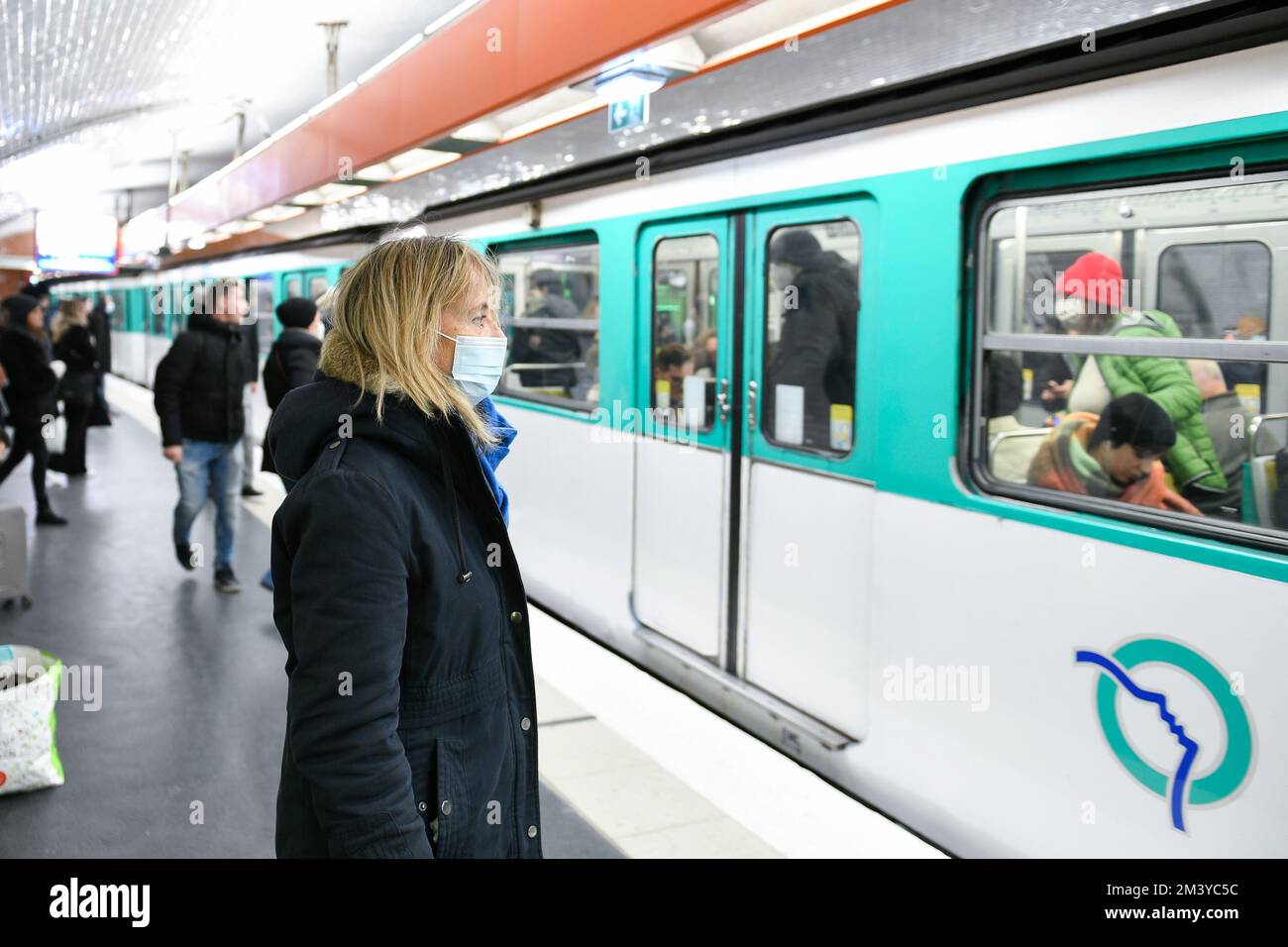 A person (woman passenger) wearing a surgical blue mask on public transport due to the Covid-19 (coronavirus) pandemic, on December 16, 2022 in Paris. Stock Photo