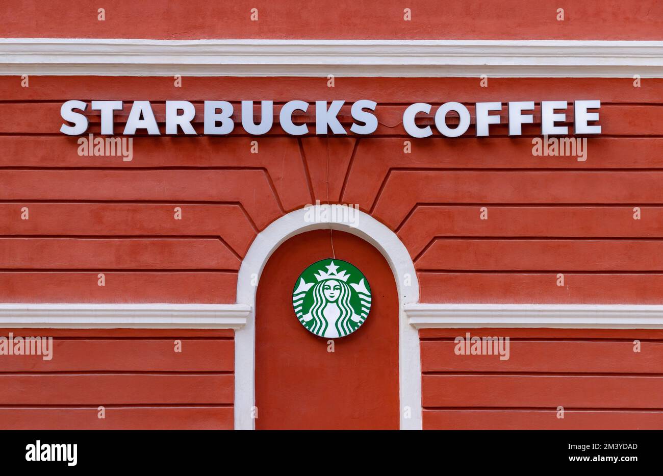 A picture of the Starbucks logo against a bright red wall, in Brasov. Stock Photo
