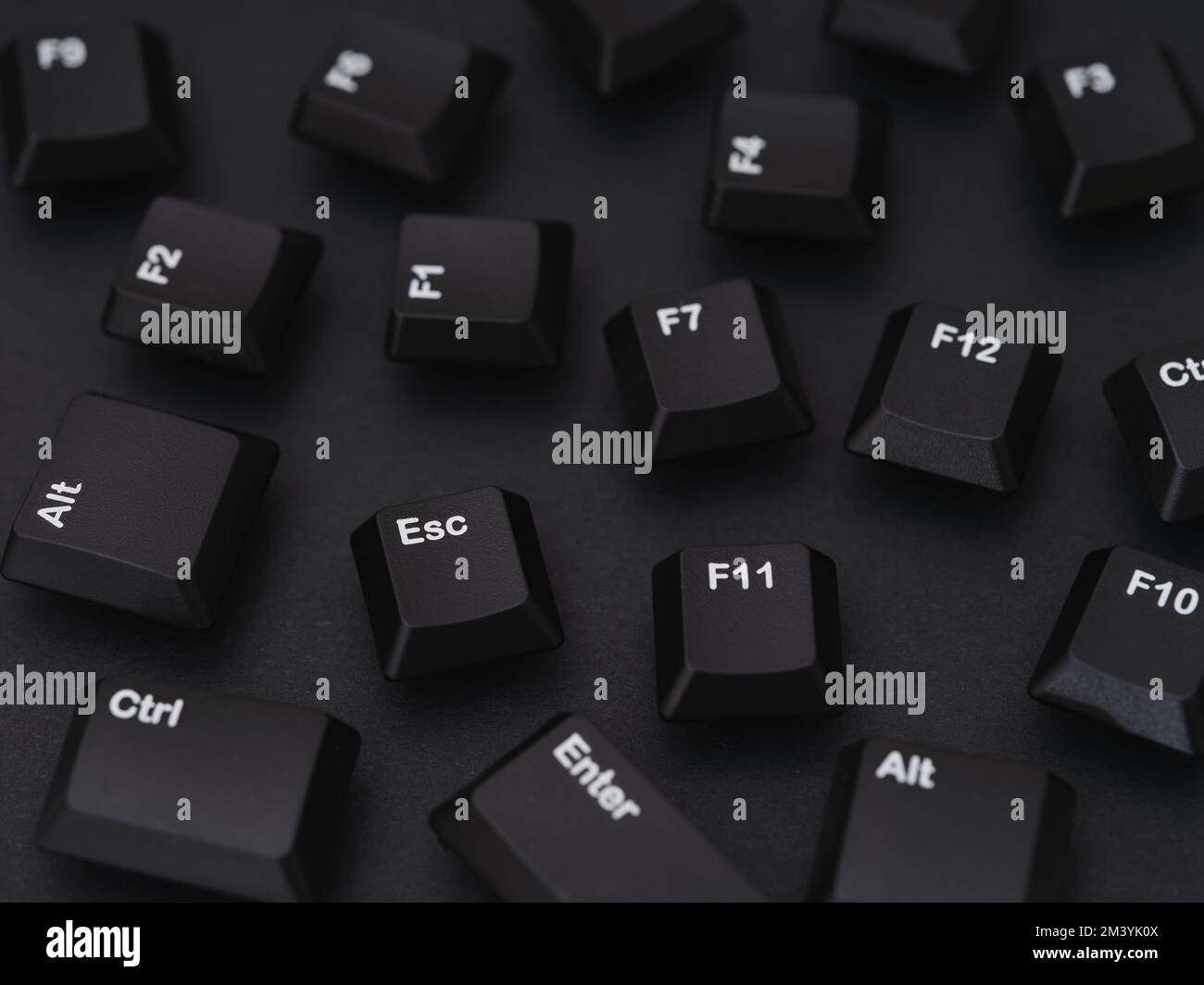 Black computer keys scattered on a black background. Close-up. Stock Photo