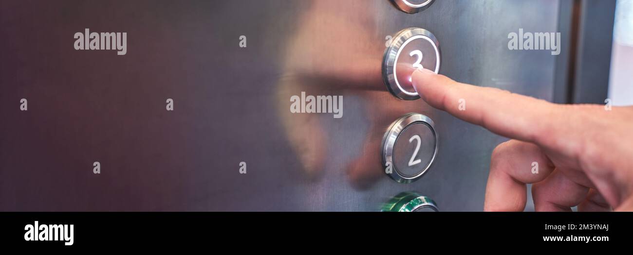 Man hand pointing number 3 button in elevator. Steel interior panel. Change year concept. Waiting new step. Up action. Start claustrophobia moment. Moving click Stock Photo