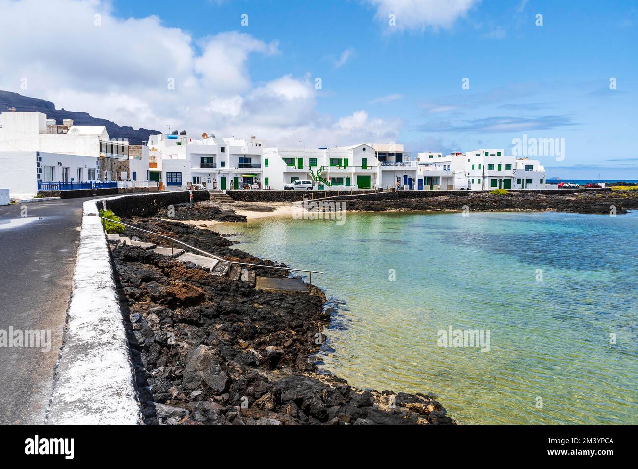 White buildings with blue and green windows by the ocean in Corralejo, Lanzarote, Canary Islands, Spain Stock Photo