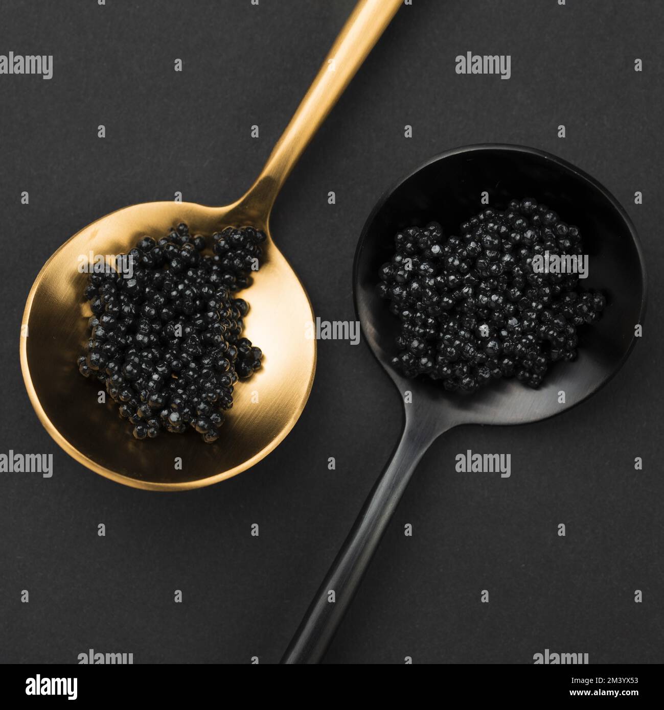 Golden and black spoon with caviar Stock Photo - Alamy