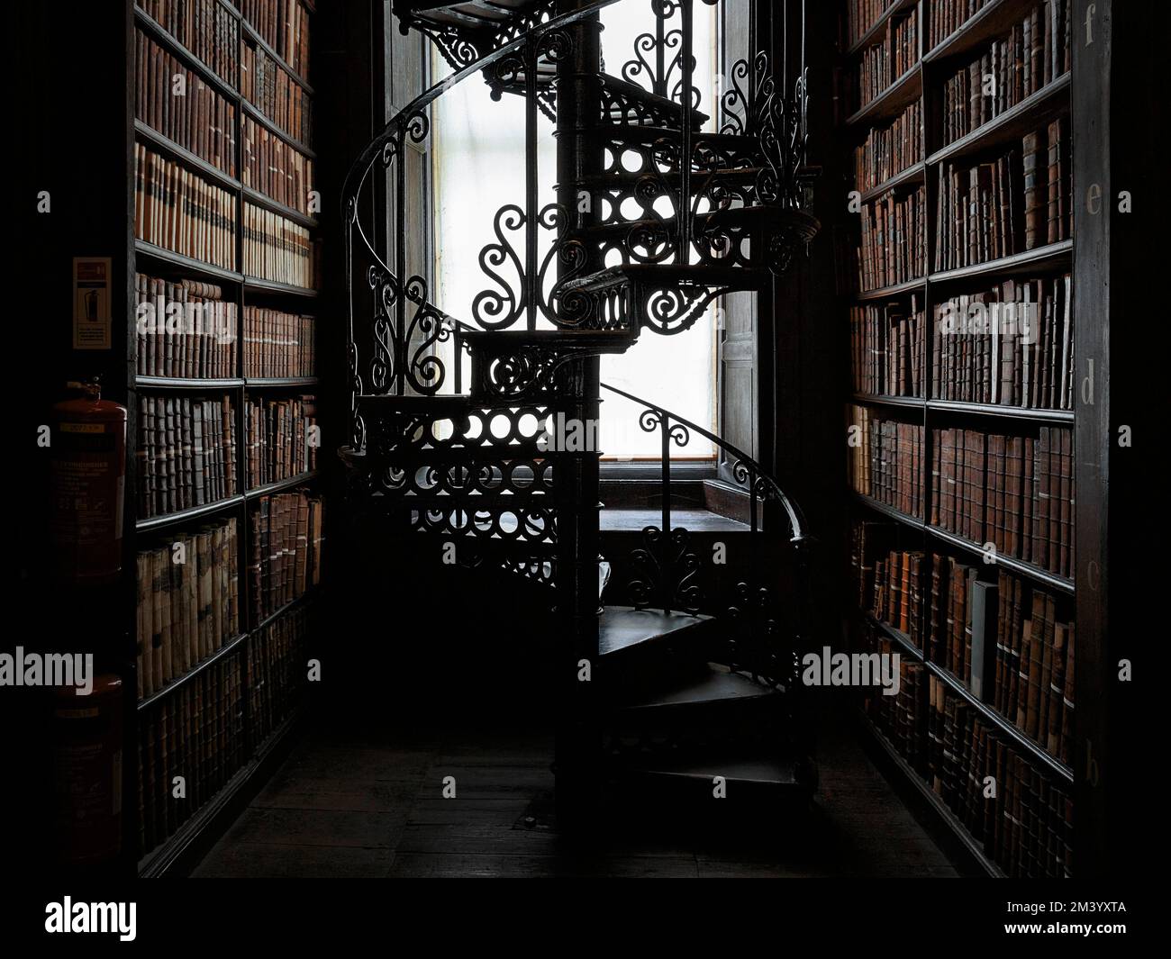 Spiral staircase and bookshelves, old 18th century library, detail, backlight, Long Room, Trinity College, University of Dublin, Ireland Stock Photo
