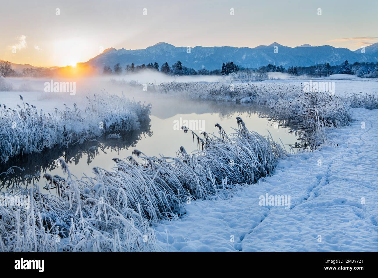 Uffing Snowy winter landscape with the Uffinger Ach at sunrise with ...