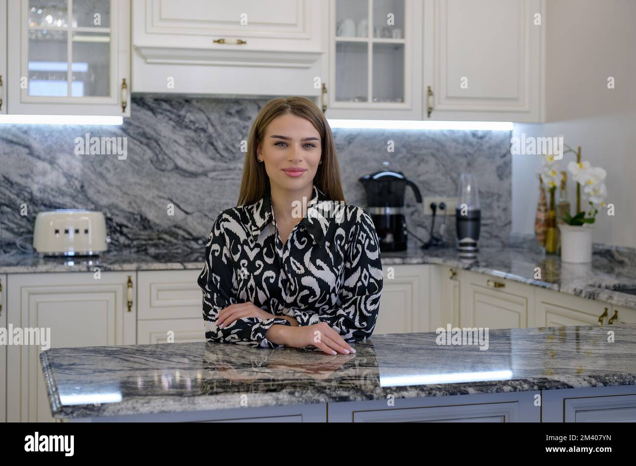 Fashionable woman looks happy and at home in her kitchen Stock Photo