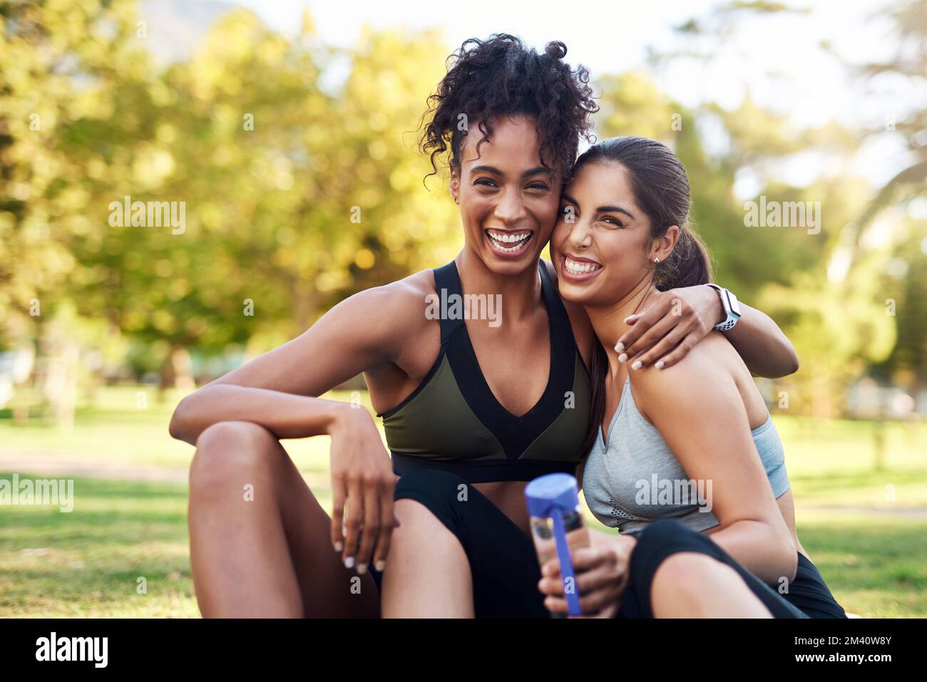 We are best friends. Cropped portrait of two attractive young women sitting close to each other and smiling while in the park. Stock Photo