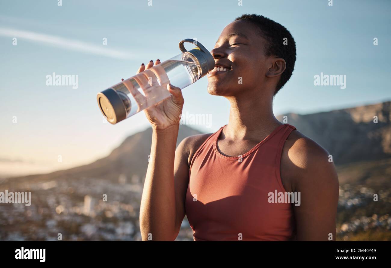 Black woman, runner and drinking water for outdoor exercise, training