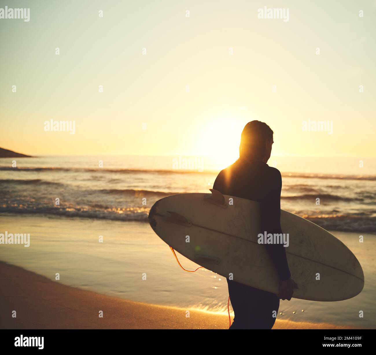 Lets go catch some amazing waves. Rearview shot of a young man carrying ...