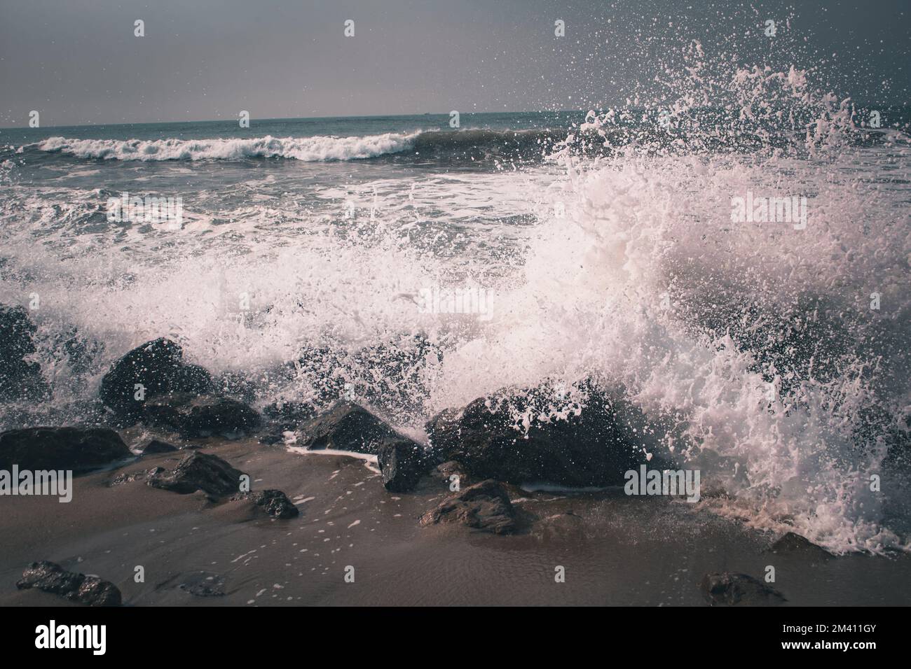 The splashing waves of the sea at the rocky shore Stock Photo - Alamy