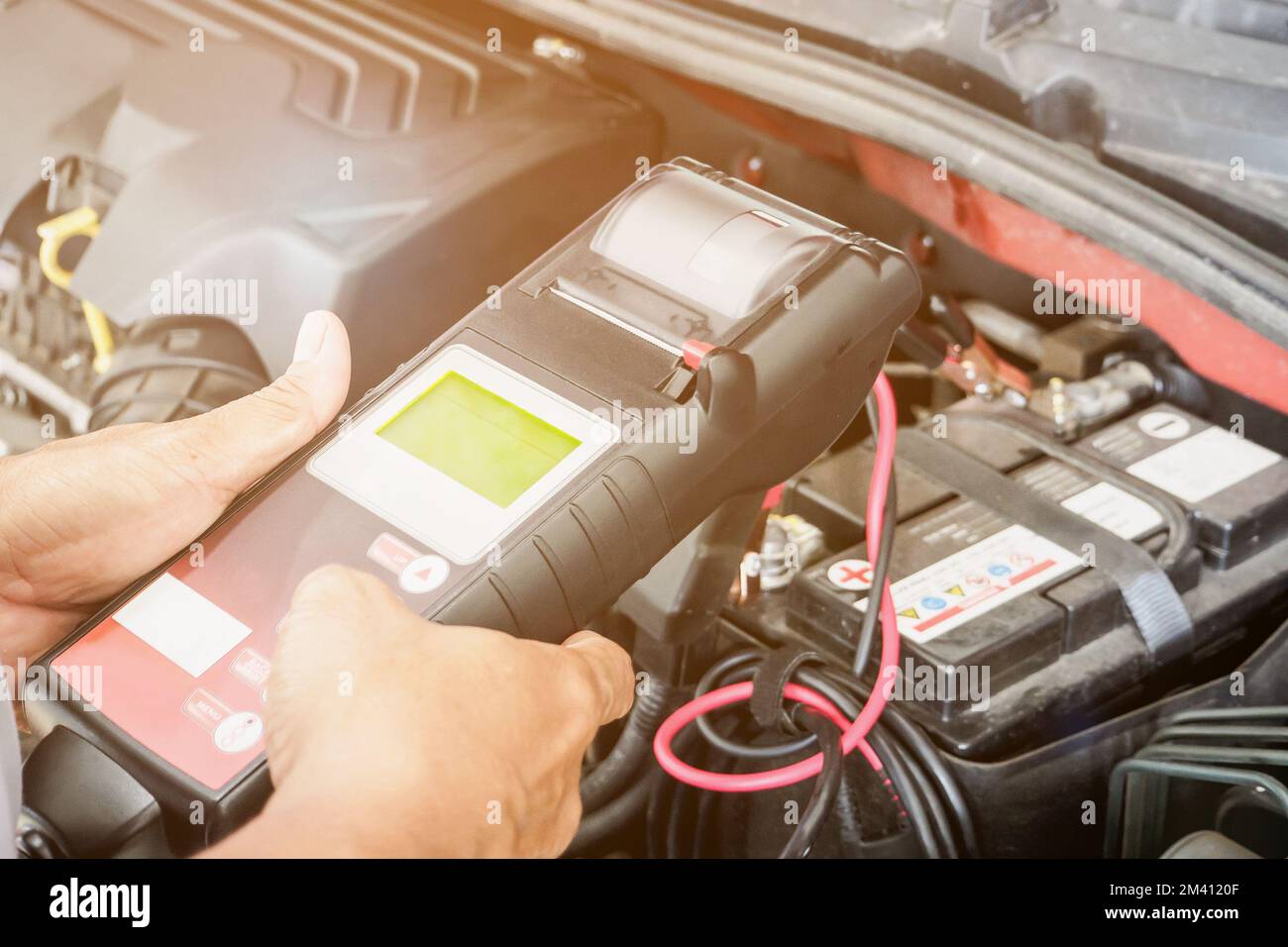 mechanic use voltmeter checking voltage of car battery in car service