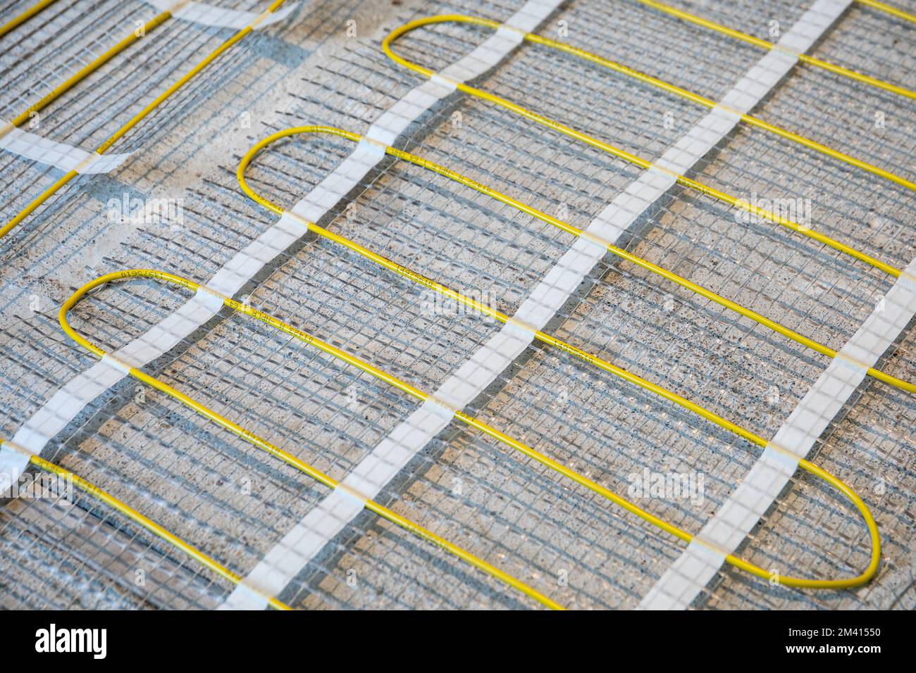 Electric warm floor laying. Cable and fiberglass mesh. Stock Photo