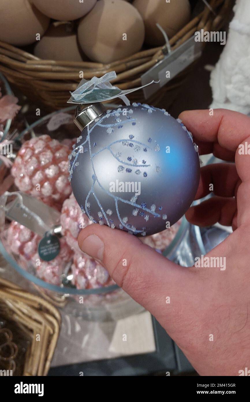 A man chooses balls for the new year tree in the store Stock Photo