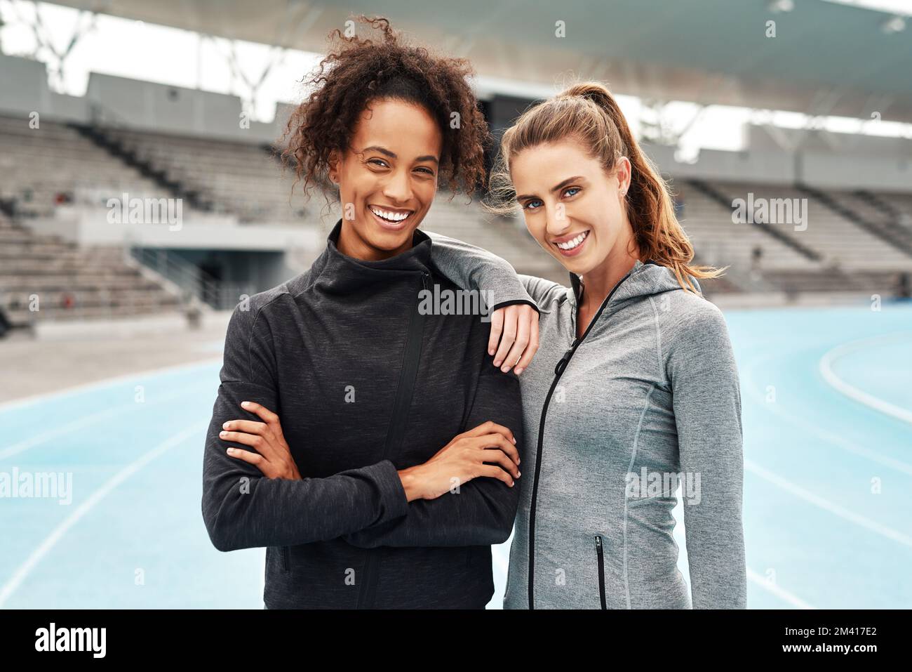 We dont wish for it, we work for it. Cropped portrait of two attractive young athletes standing together after a run on a track field during a Stock Photo