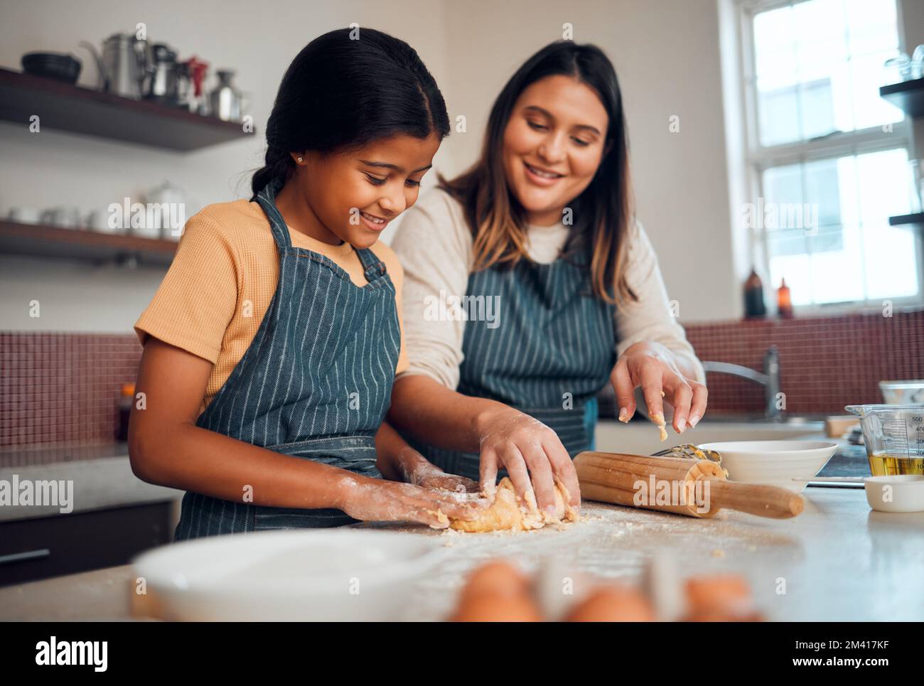 https://c8.alamy.com/comp/2M417KF/baking-family-and-love-with-a-daughter-and-mother-teaching-a-girl-about-cooking-baked-goods-in-a-kitchen-food-children-and-learning-with-an-indian-2M417KF.jpg