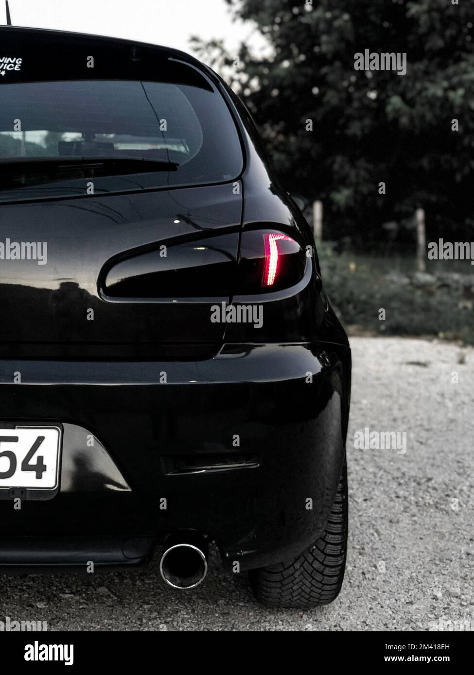 A rear view of a black Alfa Romeo 147 sports car parked outdoors Stock Photo