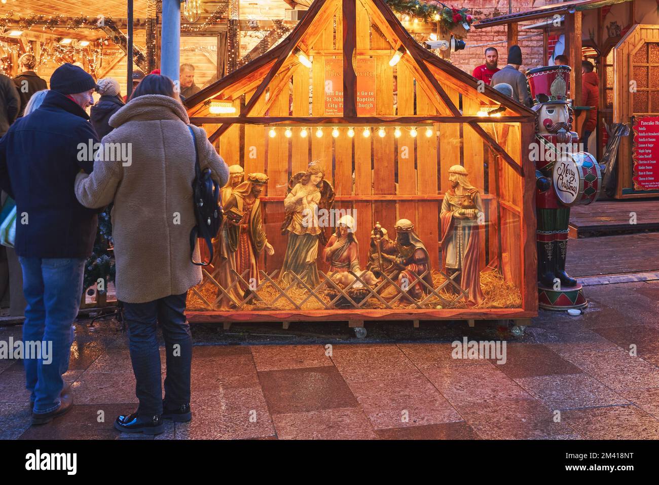 Christmas shoppers stop to view a nativity scene in Cardiff's Christmas market, Cardiff, Wales, December 2022 Stock Photo