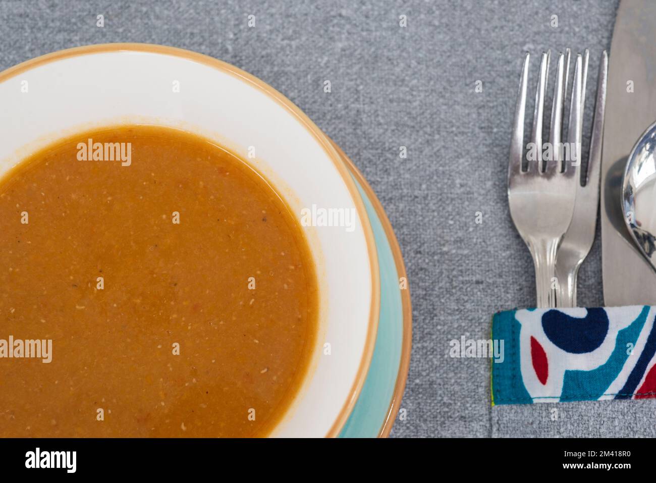 Closeup of lentil soup a la carte appetiser starter meal in bowl with cutlery at restaurant table setting Stock Photo