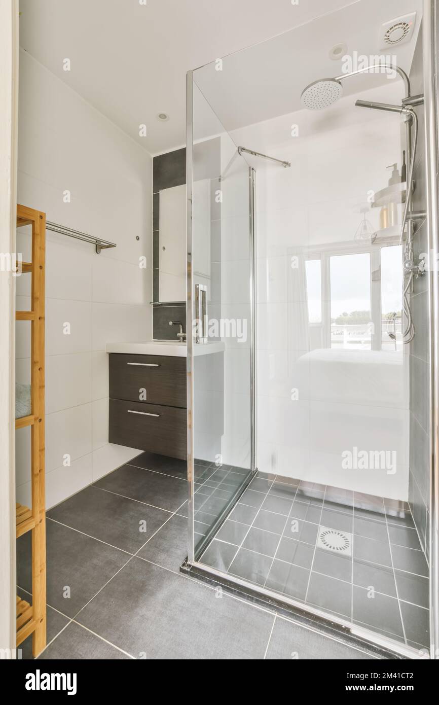 a modern bathroom with black and white tile flooring, glass shower