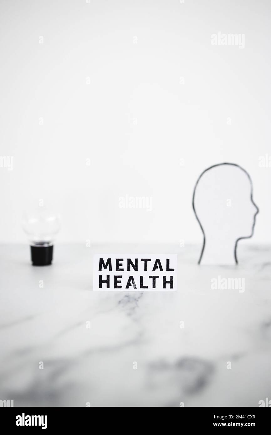mental health text next to cardboard head with light bulb, psychology and personality concept Stock Photo