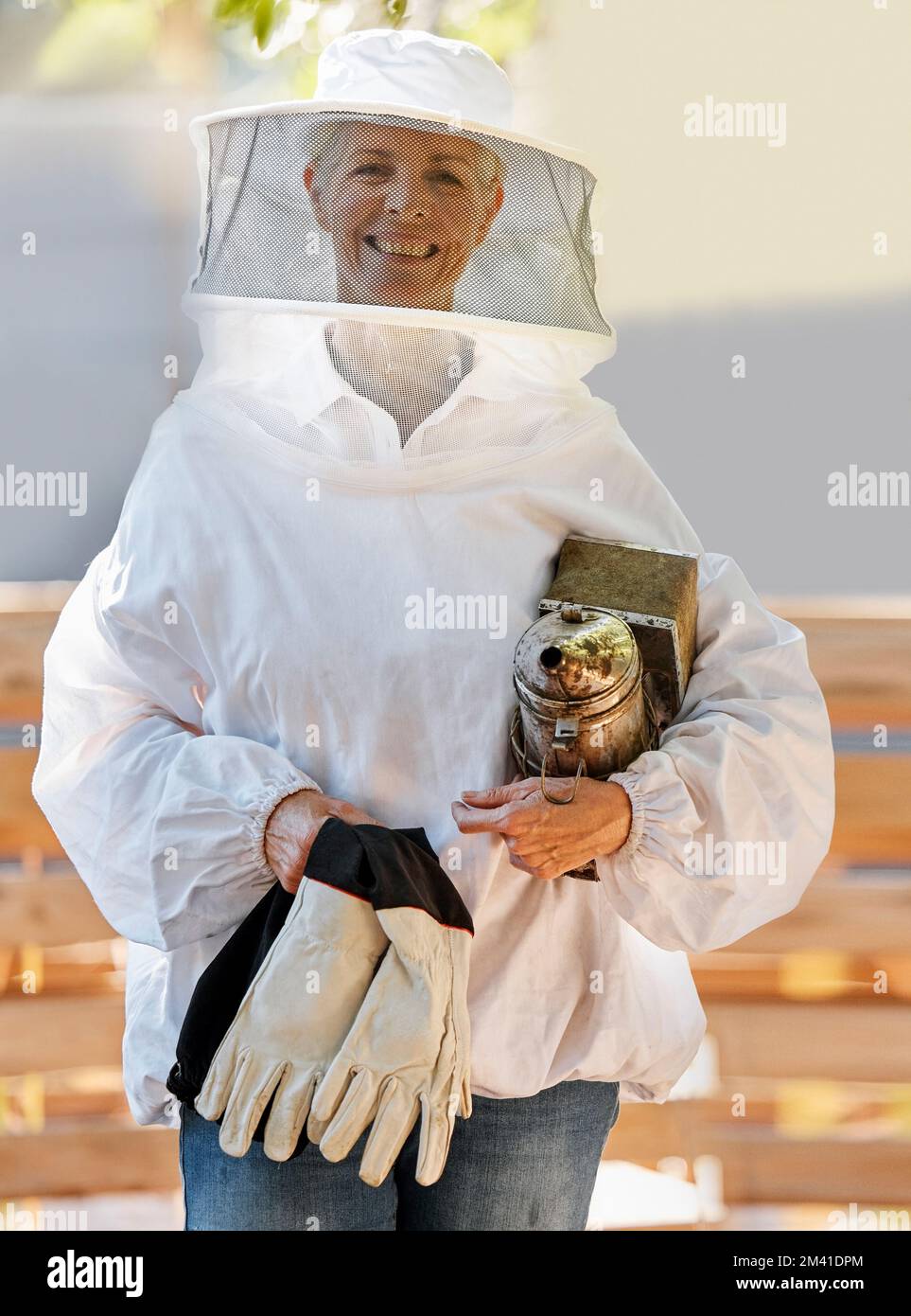 Beekeeper woman, safety portrait or farm with apiculture suit, vision or smile in summer harvesting time. Bee expert, ppe clothes or happiness in eco Stock Photo