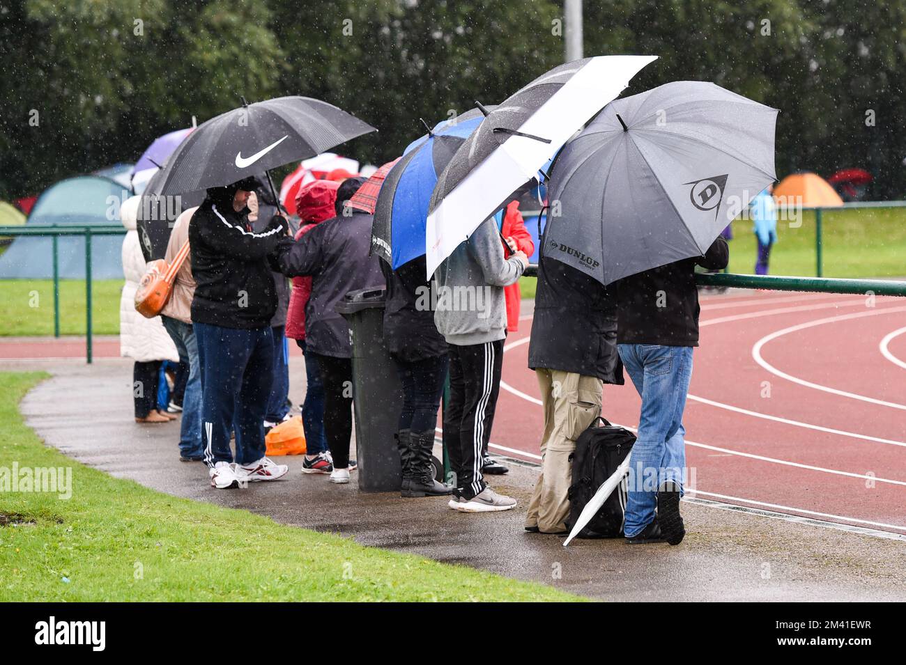 Spectators in the rain at a Junior Athletics Competition Stock Photo