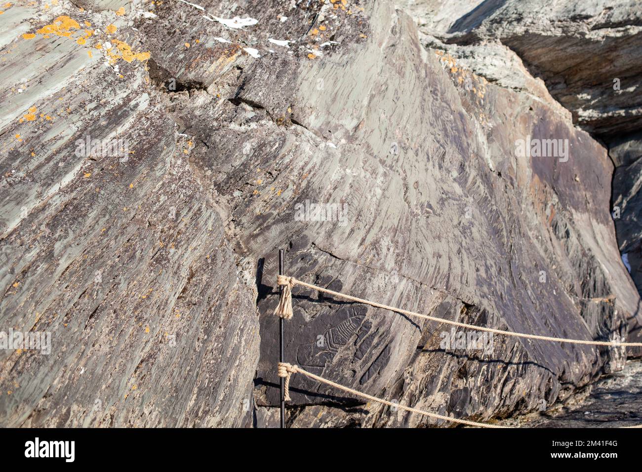 Old rock carvings of an ancient man on rocks in Siberia. The drawings ...