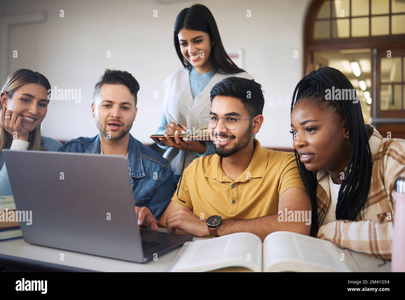 Laptop, study and students with group project for online course, e learning and education with diversity, happy and teamwork. Research video, studying Stock Photo