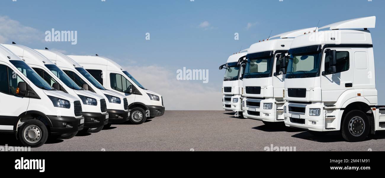 Semi trucks and delivery vans are parked in rows. Commercial fleet Stock Photo
