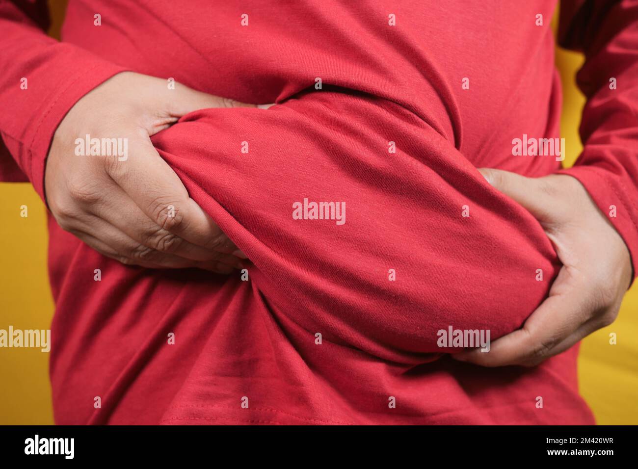 man's hand holding excessive belly fat, overweight concept Stock Photo
