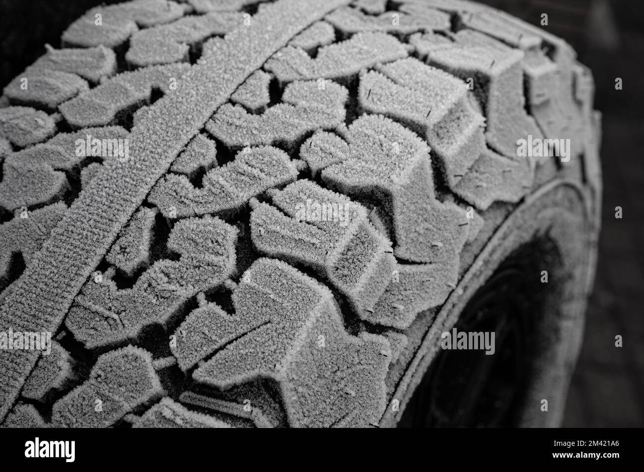 Winter tires with heavy tread over frozen with ice crystals Stock Photo