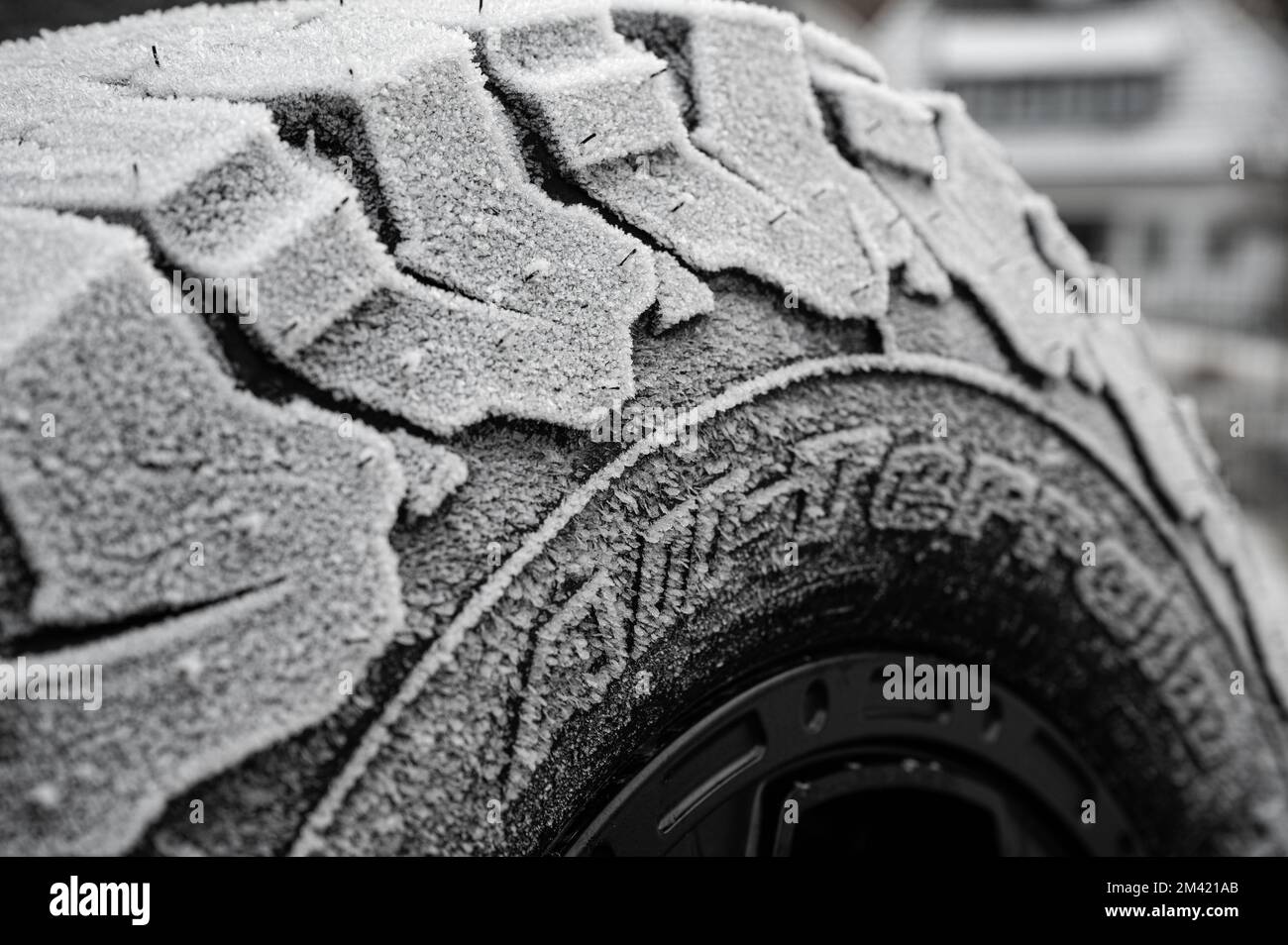 Winter tires with heavy tread over frozen with ice crystals Stock Photo