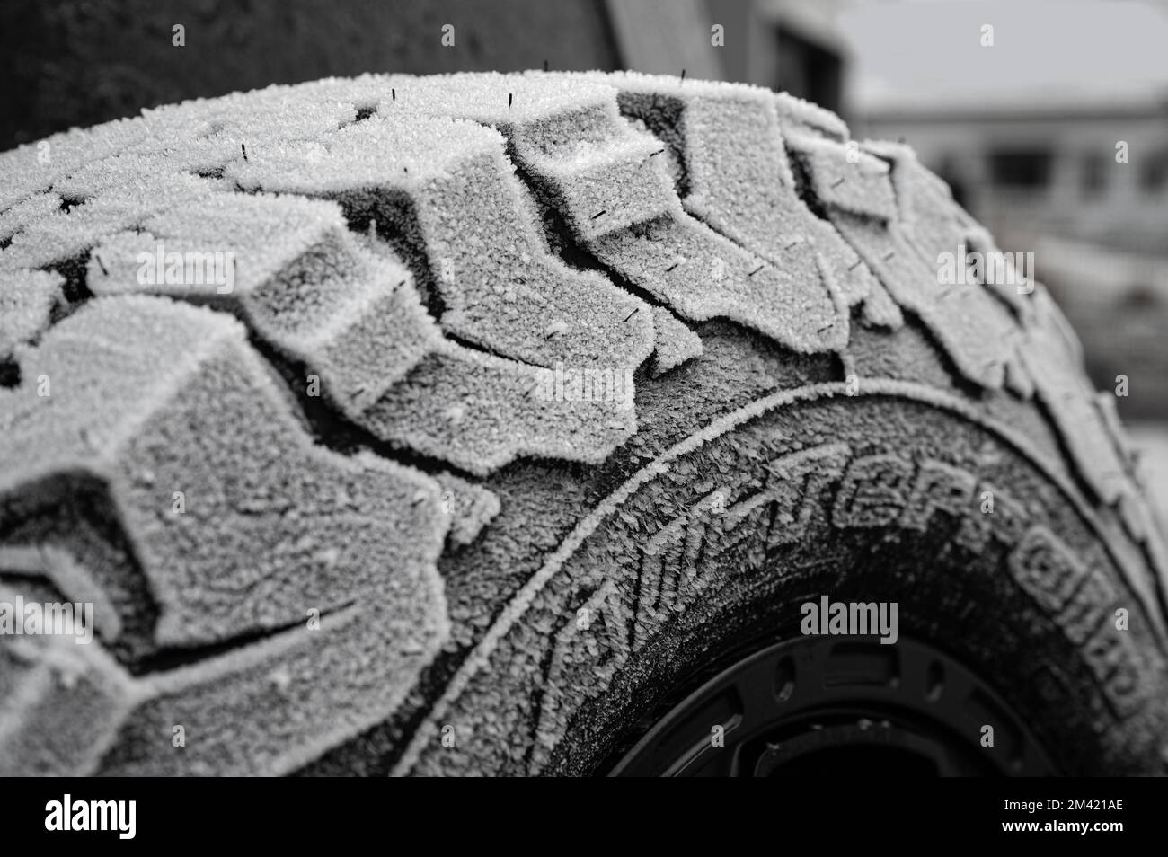 Winter tires with heavy tread over frozen with ice crystals Stock Photo