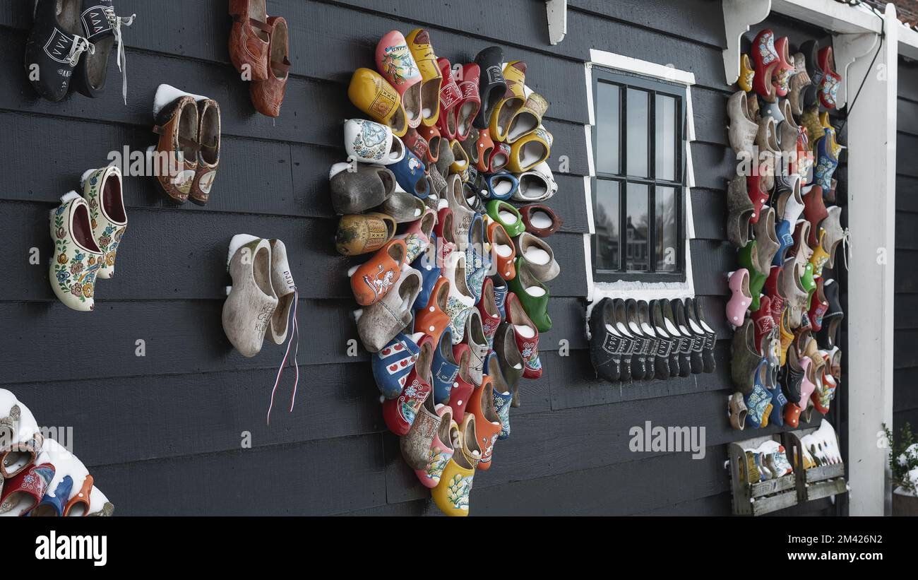 Zaandam, Netherlands, February 10, 2021:Colorful clogs against the background of a wooden wall. Stock Photo