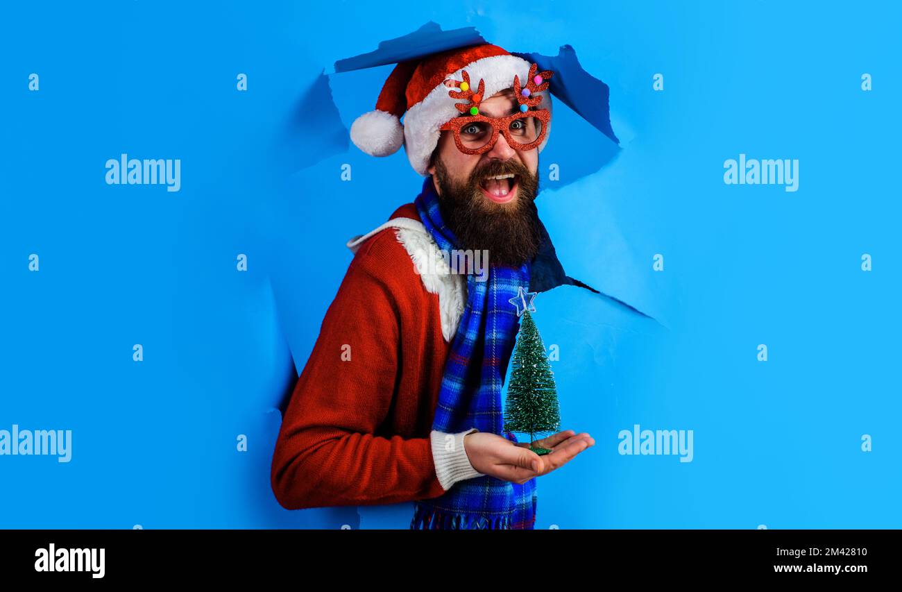 Santa Claus with Christmas tree on palm hand. Delivery service. New year shopping. Discount. Sale. Stock Photo