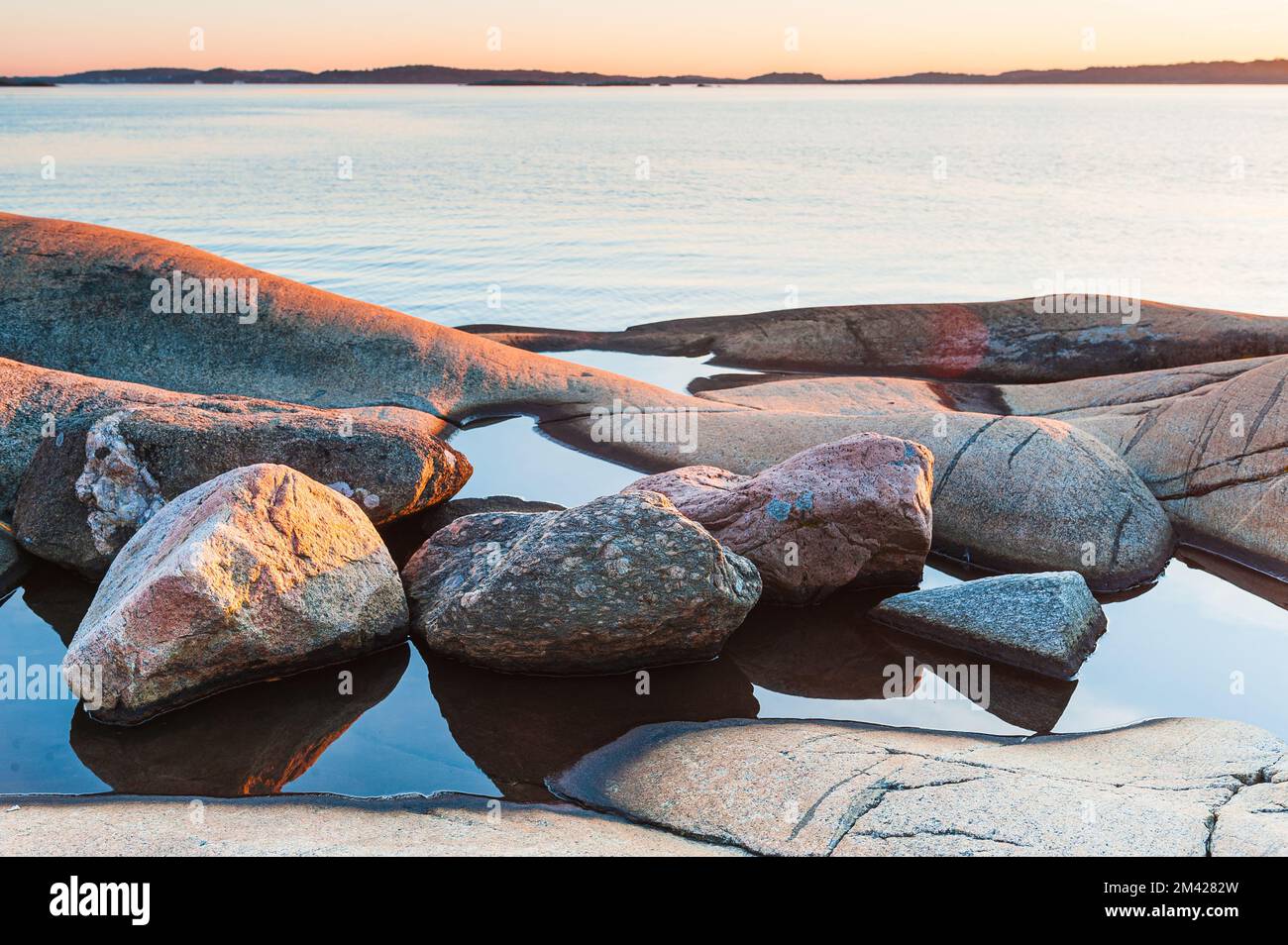 Stones lying in water in front of sea Stock Photo - Alamy
