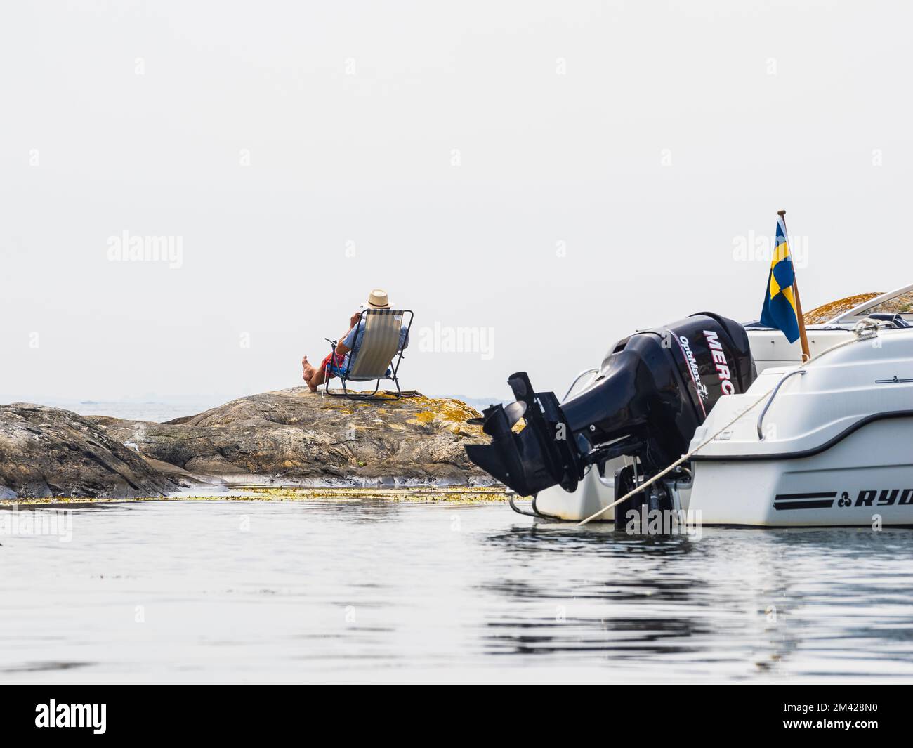 Man sitting in front of his motorboat Stock Photo