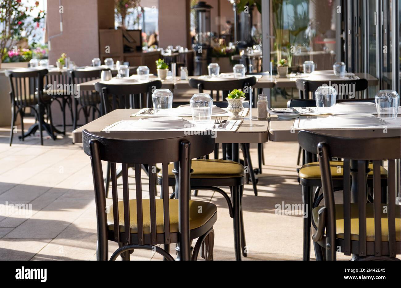 Empty table chairs in front of a restaurant. Reserved table Stock Photo